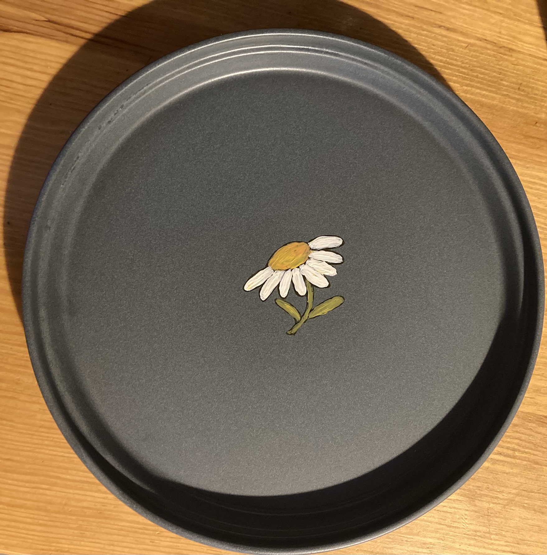 A plate hand-painted with a daisy pattern